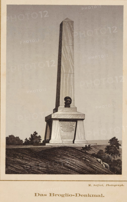 Das Broglio-Denkmal, Photo reproduction of a print of the obelisk for the Broglio brothers in the Monrepos park in Vyborg, reproduction, page, photomechanical print, photographer: M. Seifert, maker: Frey und Co. & G.H. Wiegand, Ph. (possibly), Frankfurt am Main, after print by anonymous, c. 1865 - in or before 1875, Frey und Co. & GH Wiegand, after print by, Hessen, paper, photolithography, height 141 mm x width 97 mm, garden, obelisk, needle, Leningradskaya, Vyborg, Monrepos, A tall stone obelisk rises from a tiered rectangular base situated on a sloping grassy hill, the obelisk showing subtle vertical striations and a pyramidal top, and a sculpted bust set into a recessed panel near the base, with trees and low shrubs on either side of the monument and textured ground in the foreground.