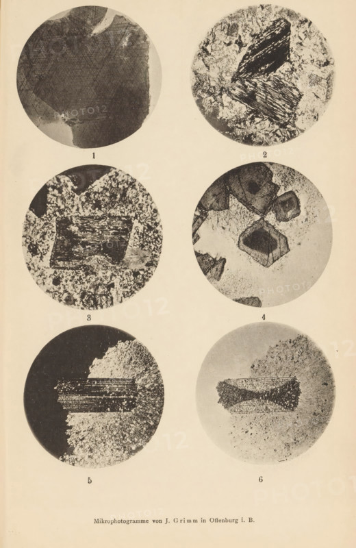 Six microscopic enlargements of minerals, page, photomechanical print, Image 1, 2 and 3 is biotite, 4, 5 and 6 is ottrelite., number: '1, 6', number: 'Tafel XXII', photographer: Emil Cohen, Greifswald, cliché maker: J. Grimm, Offenburg, c. 1880 - in or before 1885, Baden-Württemberg, Mecklenburg-Vorpommern, paper, collotype, photoprint, height 233 mm x width 149 mm, minerals and metals, A vertical sheet showing six circular grayscale close-up images arranged in two columns and three rows against a light background, each circle containing textured, granular or fibrous patterns and irregular dark shapes within varying contrast; the top left circle displays a mostly dark textured area with lighter fringes, the top right circle shows lighter mottled texture with two elongated dark, striated fragments, the middle left circle contains a rectangular dark block set against a speckled background, the middle right circle features several angular, faceted dark forms amid a lighter speckled field,...