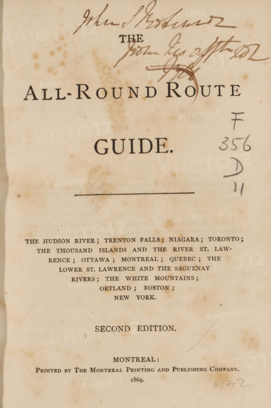 All-round route guide, book, inscription: 'John S Ro... from Lis ...', publisher: Montreal Printing and Publishing Company, Montreal, 1869, North America, pasteboard, biological material, paper, leather, printing, albumen print, height 160 mm x width 109 mm x thickness 15mm, A vertical aged book page with a faded cream background and scattered brown spots, showing a large centered title in dark serif type near the top, ink signatures and scribbles across the upper edge, a thin horizontal line below the title, handwritten pencil marks at the right margin, a block of smaller printed lines of text arranged in centered rows in the middle section, and a single-word line in larger type followed by another centered line of small printed text near the lower third, with the paper edges slightly darker and a faint curved crease on the right side.