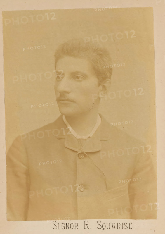 Signor R. Squarise, photograph, page, c. 1875 - in or before 1885, photographer, paper, albumen print, height 137 mm x width 97 mm, Person, Raffaello Squarise, portrait of composer, A sepia-toned portrait of a young person shown from the chest up, facing slightly to the left with short hair and a faint mustache, wearing a high-collared shirt under a buttoned jacket with a visible pocket and buttons, set against a plain background.