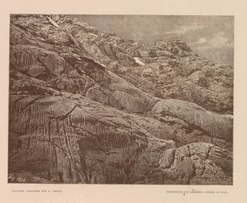 View of the Wildkarspitze, Partie im Wildkar, page, photomechanical print, number: 'XIII.', photographer: Friedrich Simony, Austria, cliché maker: Angerer & Göschl, C., Vienna, publisher: Eduard Hölzel, 1876, clichémaker, Lower Austria, paper, autotypie, height 148 mm x width 196 mm, mountain-top, peak, Tirol, Wildkarspitze, A sepia-toned image showing a large expanse of rugged rock formations filling most of the frame, with layered and grooved surfaces, ridges, cracks, and varied textures; a few pale patches contrast with the darker rock, and a sky with subtle cloud shapes appears above the rocky slopes.