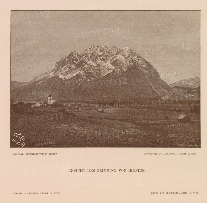 Ansicht des Grimming von Irdning, View of the Grimming, page, photomechanical print, number: 'XV.', photographer: Friedrich Simony, Austria, cliché maker: Angerer & Göschl, C., Vienna, publisher: Eduard Hölzel, 1887-10-24, Lower Austria, paper, autotypie, height 138 mm x width 190 mm, mountain-top, peak, Dachstein (Salzburg), Grimming, A sepia-toned image of a mountainous landscape with a large, rugged snow-dusted peak occupying the upper center and right, a darker forested slope in front of the mountain, and a flat valley in the foreground containing small clustered buildings, a church with a steeple, scattered houses, a line of tall slender trees, and a few isolated farm structures.