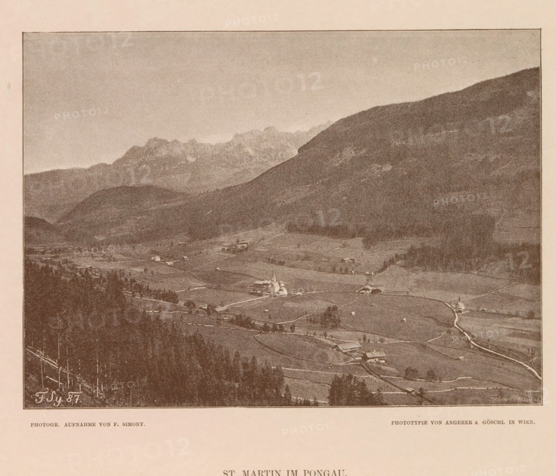 View of Sankt Martin am Tennengebirge, St. Martin im Pongau, page, photomechanical print, number: 'XVIII.', photographer: Friedrich Simony, Salzburg (city), cliché maker: Angerer & Göschl, C., Vienna, publisher: Eduard Hölzel, 1887, Lower Austria, paper, autotypie, height 142 mm x width 195 mm, city-view in general, 'veduta', Sankt Martin am Tennengebirge, A sepia-toned panoramic view showing a valley with fields and scattered buildings, a small church with a steeple near the center, winding roads and paths linking houses and farms, clusters of trees and wooded slopes in the foreground, a large rounded hillside rising on the right, distant jagged mountain peaks along the horizon, and a wide pale sky above.