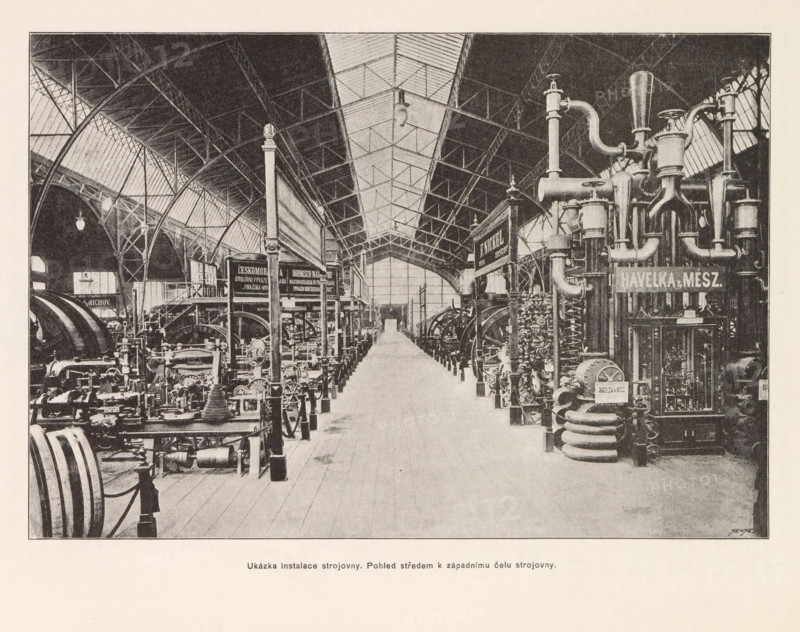 Ukázka instalace strojovny. Pohled stredem k západnimu celu strojovny, View of the engine room at the Výstavište in Prague, page, photomechanical print, Výstavište, cliché maker: Carl Bellmann, Prague, c. 1888 - in or before 1893, photographer, paper, autotypie, height 178 mm x width 258 mm, interior, representation of a building, machines, parts of machines, tools and appliances, A large indoor industrial hall with a high arched roof and a central skylight running along its length, flanked on both sides by rows of heavy machinery and metal equipment, including tall vertical pipes, coiled tubes, and cylindrical vessels clustered on the right and various engines, flywheels, and mechanical components arranged on the left, all set on a wooden plank floor with a clear central aisle leading toward a distant doorway, supported by metal columns and trussed beams that form curved arches and latticework overhead, with hanging light fixtures visible beneath the roof and small decorative finials ...