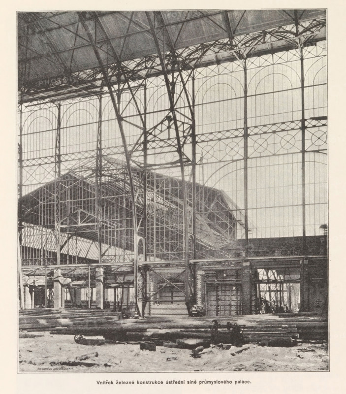Construction of the Industrial Palace under construction in Prague, Stavba veze na prumyslovem paláci dne 15. ledna r. 1891, page, photomechanical print, Výstavište, cliché maker: Carl Bellmann, Prague, 1891-01-15, photographer, paper, autotypie, height 218 mm x width 190 mm, building-site, A large interior space dominated by tall iron framework and arched glass panels fills the scene, with slender vertical columns and intersecting diagonal supports forming a lattice against the translucent wall panels; elaborate iron trusses and curved braces span the upper area, and a pitched roof structure with additional metal scaffolding and beams is visible behind the foreground framework. The lower foreground shows a rough floor surface scattered with long cylindrical logs and beams lying parallel, and a few pieces of machinery or carts near the piled timbers. Throughout the image there are layered metal walkways, platforms, and open archways with visible vertical and horizontal bars, and the ov...