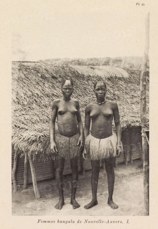 Femmes bangala de Nouvelle-Anvers I, Portrait of two women from the Bangala in New Antwerp, page, photomechanical print, number: 'Pl. 33.', photographer: Franz Thonner, New Antwerp, cliché maker: Stengel & Markert, Dresden, 1896, Saxony, paper, collotype, photogravure, height 162 mm x width 110 mm, adult woman, Two topless women stand side by side in front of a thatched structure, both wearing grass skirts and barefoot, with one woman wearing a necklace and the other a bracelet, their arms hanging by their sides, hair styled close to the scalp, and a vertical post visible at the right edge of the image.