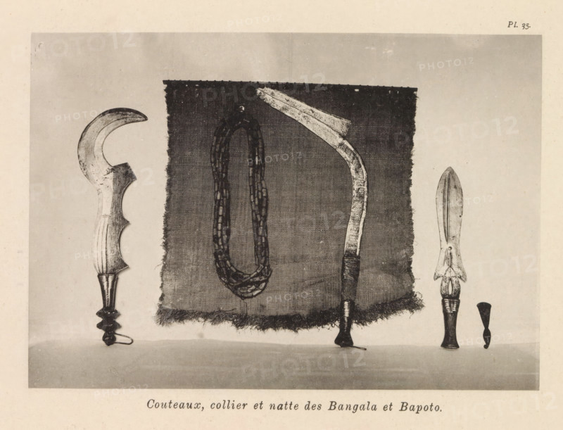 Couteaux, collier et wet des Bangala et Bapoto, Knives, necklace and a mat of the Bangala and Bapoto, page, photomechanical print, number: 'Pl. 35.', photographer: Franz Thonner, Congo (country), cliché maker: Stengel & Markert, Dresden, 1896, Saxony, paper, collotype, light printing, height 110 mm x width 158 mm, tools, aids, implements, crafts and industries: knife, necklace, door furniture, eg boot scraper, brush, doormat, A rectangular piece of woven cloth with frayed edges is centered against a plain background, with a looped necklace of bead-like segments hanging down its middle; to the right of the cloth a curved implement with a decorated handle and a blade that narrows then flares is positioned vertically, its handle wrapped near the base, and to the far right a spear-like object with a double-edged blade sits above a carved handle; to the left of the cloth a crescent-shaped blade with a carved handle and an ornate lower grip is visible.