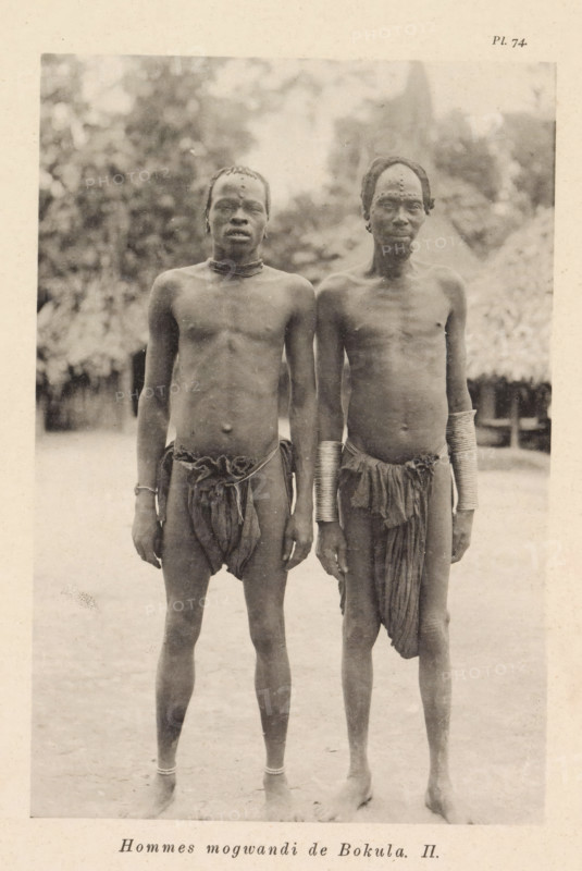Hommes mogwandi de Bokula II, Portrait of two men from the Ngbandi at Bokula, page, photomechanical print, number: 'Pl. 74.', photographer: Franz Thonner, Bokula, cliché maker: Stengel & Markert, Dresden, 1896, Saxony, paper, collotype, photoprint, height 163 mm x width 110 mm, adult man, A sepia-toned photograph of two shirtless men standing side by side facing the camera, both wearing simple loincloths and ankle bands, with one man wearing multiple stacked metal bracelets on both forearms and the other wearing a single bracelet on one wrist; both men have short hair with visible decorative markings or scars on their foreheads and chests, and they stand on bare ground with blurred vegetation and a thatched hut visible in the background.