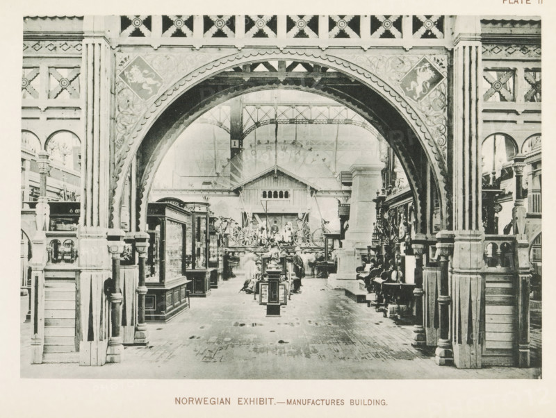 Norwegian exhibit.- Manufactures Building, Exhibition of Norway at the World's Columbian Exposition in Chicago in 1893, page, photomechanical print, number: 'Plate 11', photographer: Charles Dudley Arnold, Chicago, photographer: HD Higinbotham, cliché maker: anonymous, 1893, Charles Dudley Arnold, HD Higinbotham, photographer, cliché maker, North America, Illinois, paper, collotype, photoprint, height 134 mm x width 191 mm, world fair, world exhibition, World's Columbian Exposition, A large ornate archway with carved details frames an indoor scene of a spacious exhibition hall. Wooden columns and decorative panels flank the arch, showing repeated geometric motifs and floral carvings. Inside the hall are display cases, pedestals, and various wooden furnishings arranged along a central aisle. A row of decorative wheels and a small structure with a gabled roof sit toward the back beneath a high iron framework ceiling. People in period clothing are scattered throughout the space, some stan...
