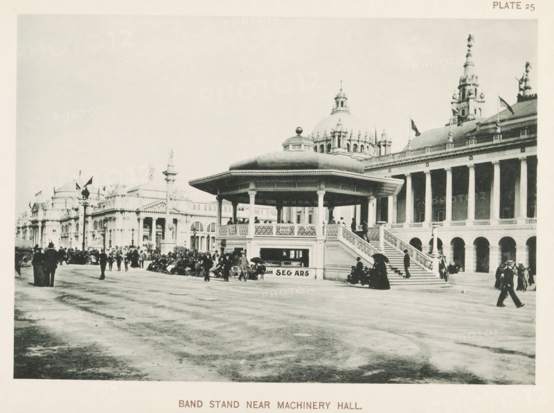 Band stand near Machinery Hall, Bandstand at the World's Columbian Exposition in Chicago in 1893, page, photomechanical print, number: 'Plate 25', photographer: Charles Dudley Arnold, Chicago, photographer: HD Higinbotham, cliché maker: anonymous, 1893, Charles Dudley Arnold, HD Higinbotham, photographer, cliché maker, North America, Illinois, paper, collotype, photoprint, height 134 mm x width 191 mm, world fair, world exhibition, music-hall - AA - open-air performances, World's Columbian Exposition, A large octagonal bandstand with a domed roof and decorative railings stands on a raised platform with a broad staircase, surrounded by groups of people in period clothing, some seated and some standing under umbrellas; behind it are grand classical buildings with columns, arched openings, domes, statues, and flagpoles, and the open paved foreground stretches toward the viewer with scattered pedestrians and carriages along the street.