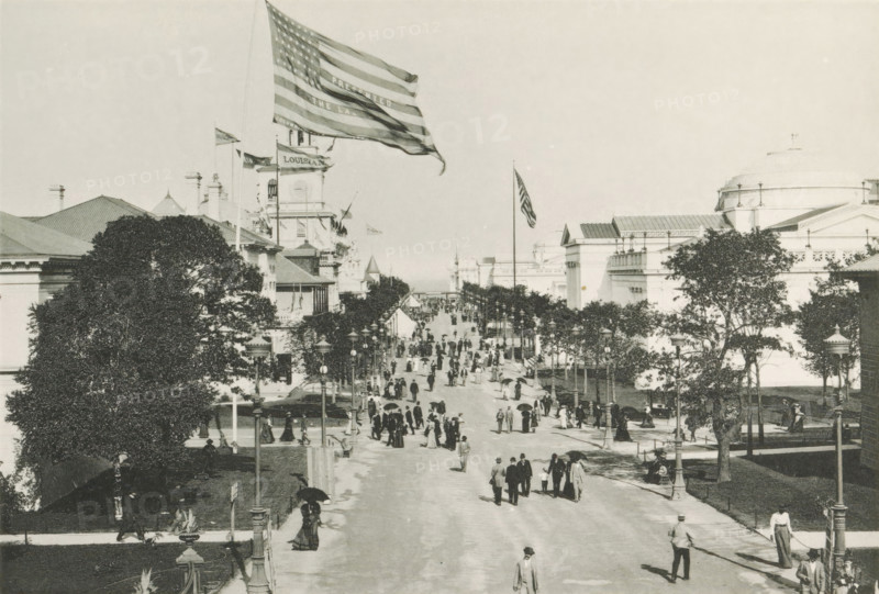 Avenue of State Buildings, View of the street lined with state pavilions during the World's Columbian Exposition in Chicago in 1893, page, photomechanical print, number: 'Plate 64', photographer: Charles Dudley Arnold, Chicago, photographer: HD Higinbotham, clichémaker: anonymous, 1893, Charles Dudley Arnold, HD Higinbotham, photographer, clichémaker, North America, Illinois, paper, collotype, photogravure, height 129 mm x width 190 mm, world fair, world exhibition, World's Columbian Exposition, A wide boulevard flanked by large classical buildings and rows of lamp posts stretches into the distance, with numerous people strolling along the street and sidewalks, some holding parasols and wearing period clothing and hats. Large trees and planted areas line the edges of the avenue, and tall flagpoles rise above the buildings, one with a large flag billowing in the breeze. Architectural details include domes, pediments, and ornate facades on the buildings framing the scene. The image has a...