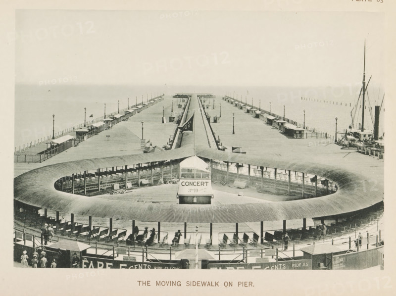 The moving sidewalk on pier, View of a pier in Lake Michigan with a moving platform for the World's Columbian Exposition in Chicago in 1893, page, photomechanical print, number: 'Plate 83', photographer: Charles Dudley Arnold, Chicago, photographer: HD Higinbotham, clichémaker: anonymous, 1893, Charles Dudley Arnold, HD Higinbotham, photographer, clichémaker, North America, Illinois, paper, collotype, photogravure, height 133 mm x width 191 mm, pier, quay, wharf, world fair, world exhibition, World's Columbian Exposition, A wide wooden pier extending into the water with two long parallel walkways lined by small covered shelters and tall lamp posts, a curved wooden structure in the foreground forming a circular open area with benches and a central covered kiosk, a narrow track running from the circular area toward the pier end, people visible on the circular benches and walking near the entrance area, boats moored at the pier’s right side with tall masts, and a calm horizon where the se...
