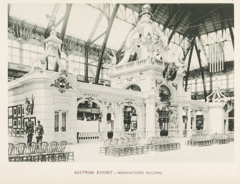 Exhibition of Austria at the World's Columbian Exposition in Chicago in 1893, Austrian exhibit.- Manufactures Building, page, photomechanical print, number: 'Plate 9', photographer: Charles Dudley Arnold, Chicago, photographer: HD Higinbotham, clichémaker: anonymous, 1893, Charles Dudley Arnold, HD Higinbotham, photographer, cliché maker, North America, Illinois, paper, collotype, photoprint, height 134 mm x width 190 mm, world fair, world exhibition, World's Columbian Exposition, A large ornate exhibition structure with decorative arches, sculpted figures, and balustrades fills an indoor space beneath a high iron-and-glass roof. The façade shows carved coats of arms, crowned finials, and ornamental reliefs, with statues integrated into the architecture and winged figures atop the arches. Rows of simple wooden chairs are arranged in front of the building on the open floor. Two uniformed figures stand near a doorway on the left beside framed pictures mounted on the wall. Large industria...