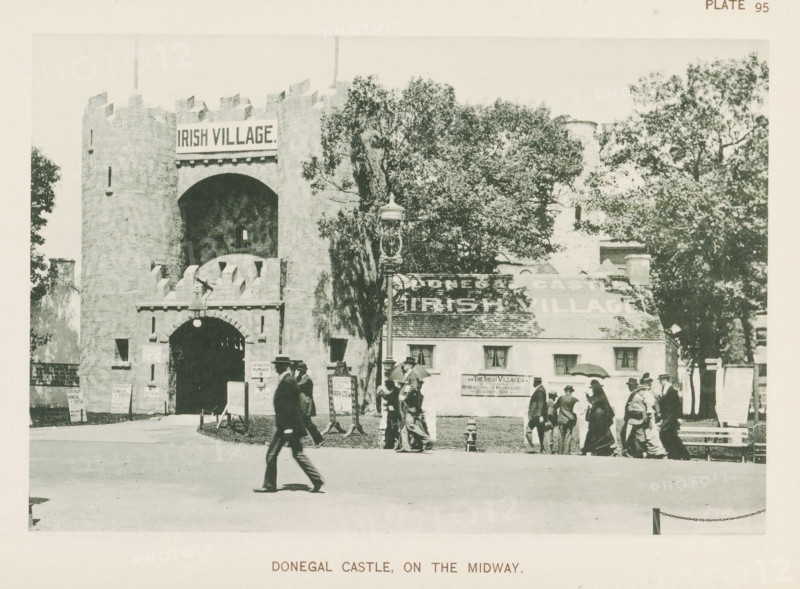 Donegal Castle, on the Midway, View of Ireland's contribution with a replica of Donegal Castle at the World's Columbian Exposition in Chicago in 1893, page, photomechanical print, number: 'Plate 95', photographer: Charles Dudley Arnold, Chicago, photographer: HD Higinbotham, clichémaker: anonymous, 1893, North America, Illinois, paper, collotype, photogravure, height 129 mm x width 190 mm, castle, world fair, world exhibition, World's Columbian Exposition, A stone castle entrance with battlements and a large arched doorway stands left of center, flanked by walls and a round tower, and a cottage-style building with a sloped roof is adjacent to it on the right, partially obscured by tall leafy trees; a decorative lamppost stands near the center foreground, several small freestanding signs or boards are placed near the castle entrance, and groups of people in early twentieth-century clothing and hats are walking or standing in front of the buildings, with one person striding across the op...