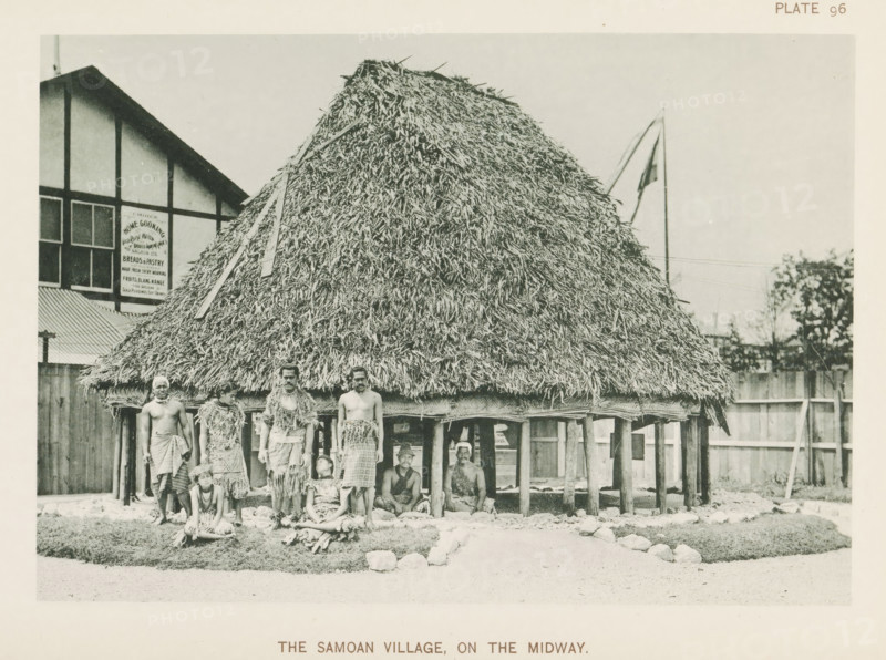 The Samoan village, on the Midway, House and people from Samoa at the World's Columbian Exposition in Chicago in 1893, page, photomechanical print, number: 'Plate 96', photographer: Charles Dudley Arnold, Chicago, photographer: HD Higinbotham, cliché maker: anonymous, 1893, Charles Dudley Arnold, HD Higinbotham, photographer, cliché maker, North America, Illinois, paper, collotype, photoprint, height 132 mm x width 190 mm, world fair, world exhibition, World's Columbian Exposition, A large thatched structure on stilts with a steep, densely layered roof occupies the center of the image, with wooden poles visible beneath it and a woven or textured skirt around the base; several people stand and sit in front of and beneath the structure wearing skirts and garments made of natural fibers and leafy materials, some with decorative collars or sashes, and a few are seated on the ground on grassy patches or low mats; to the left a timber-framed building with rectangular windows and a corrugated...