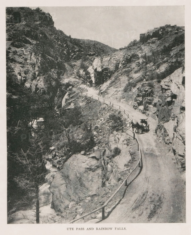 In Monument Park, View of rock formations in Monument Park in Colorado, page, photomechanical print, Monument Park, cliché maker: New York Photo-Gravure Company, New York (city), c. 1888 - in or before 1893, photographer, North America, Colorado, Las Animas, paper, autotypie, height 78 mm x width 83 mm, landscapes, ravine, chasm, abyss, canyon, A narrow dirt road winds along a rocky canyon with a wooden railing on the outer edge, steep rock walls rising on both sides and scattered vegetation clinging to the slopes, a horse-drawn carriage with a covered top and a person beside it is on the road, jagged boulders and rock ledges fill the foreground and midground, a stream cascades through rocks below with bare and leafy trees along its banks, distant hilltops are visible against a pale sky.