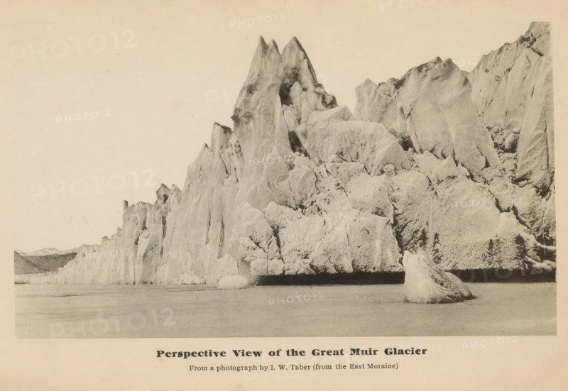 Peerspective view of the great Muir glacier, View of the Muir Glacier, page, photomechanical print, inscription: 'From a photograph by IW Taber (from the East Moraine)', photographer: Isaiah West Taber, Skagway-Hoonah-Angoon, cliché maker: anonymous, c. 1885 - in or before 1890, North America, Alaska, paper, collotype, photoprint, height 102 mm x width 175 mm, Print opposite title page., glacier, Muir Glacier, A wide, sepia-toned photograph shows a rugged ice formation rising from calm water, with jagged, towering peaks and steep, angular faces that display a variety of textured surfaces and crevices; a large detached chunk of ice floats near the base of the formation in the foreground, while the water in front appears smooth and reflective; the sky above is pale and empty, and faint distant landforms are visible at the far left edge of the image.