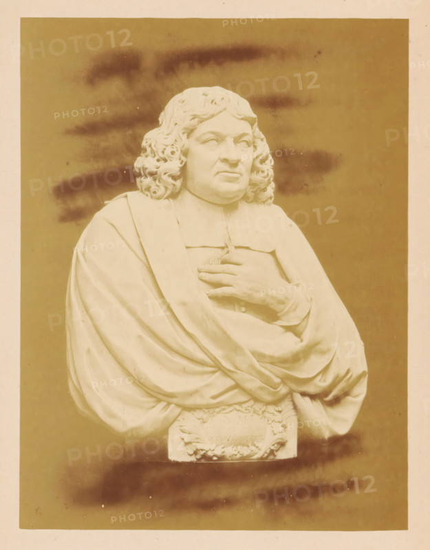 Marble bust of Mayor Johannes Munter by Bartholomeus Eggers, Marble Bust of Mayor Joh. Munter, by B. Eggers, photograph, page, number: 'No. 479*.', photographer: Pieter Oosterhuis, Amsterdam, 1876, paper, albumen print, height 166 mm x width 126 mm, Person, Johannes Munter, piece of sculpture, reproduction of a piece of sculpture, Historical Exhibition Amsterdam, Oudemannenhuis (Amsterdam), Period, A sepia-toned photograph of a marble bust showing a person with long curly hair and a solemn facial expression wearing draped robes, one hand placed on the chest and the other partly visible beneath the folds, with carved decorative elements at the base and a plain background with darker smudged areas.