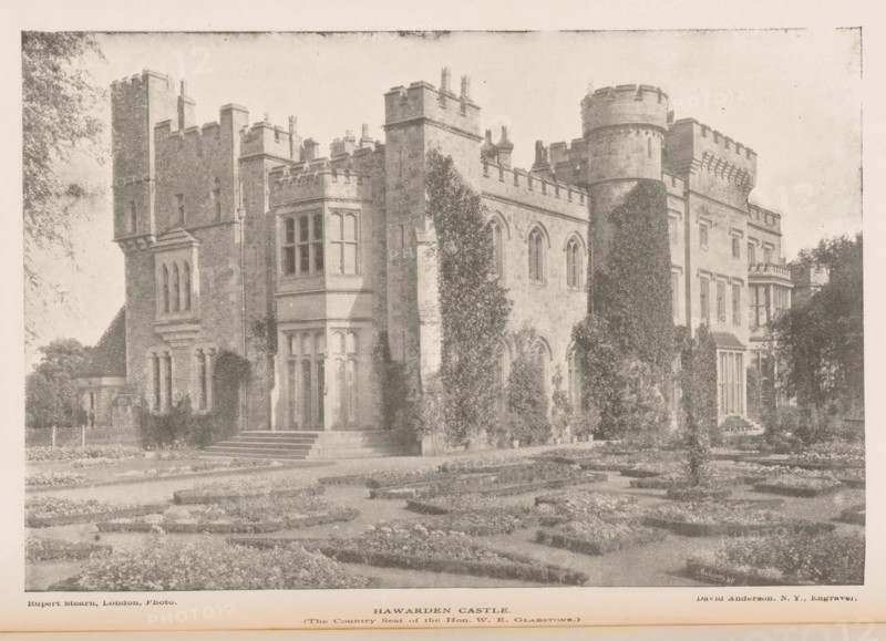 View of Hawarden Castle, Hawarden Castle, page, photomechanical print, inscription: 'The Country Seat of the Hon. WE Gladston', inscription: 'Anderson NY', photographer: Rupert Stearn, cliché maker: David H. Anderson, 1887 - 1907, paper, autotypie, height 115 mm x width 171 mm, castle, façade (of house or building), Wales, Hawarden, A sepia-toned image of a large stone building with battlements, towers, and tall narrow windows, framed by trees and climbing plants, with formal garden beds in the foreground and a path leading toward the entrance.
