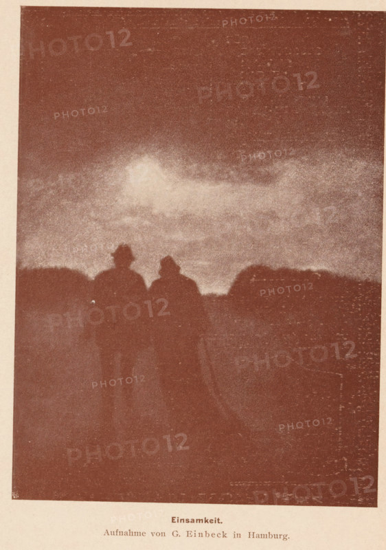 View of two unknown walking men with hats, Einsamkeit, page, photomechanical print, monogram: 'MR, &Co', photographer: George Einbeck, cliché maker: Meisenbach, Riffarth & Cie. (possibly), Berlin, printer (person): Wilhelm Knapp Verlag, Halle an der Saale, c. 1893 - in or before 1898, printer (person), Saxony-Anhalt, paper, autotypie, height 164 mm x width 120 mm, mother and baby or young child, A grainy sepia image showing a dark sky with lighter clouded area near the center and a silhouetted horizon, with two shadowy human figures standing close together in the foreground wearing hats, their forms contrasted against the lighter band of sky above the horizon.