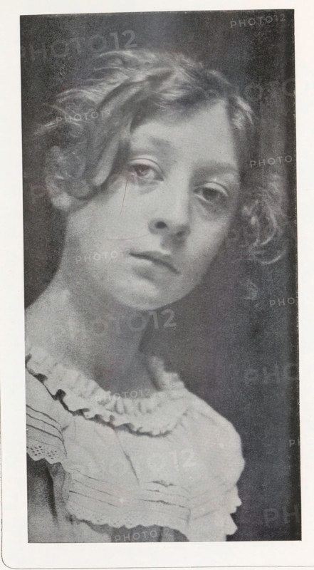 Portrait of an unknown girl, page, photomechanical print, photographer: Ed. Hannon, Brussels, cliché maker: anonymous, c. 1893 - in or before 1898, paper, autotypie, height 194 mm x width 100 mm, girl (child between toddler and youth), A grayscale portrait of a young person with wavy hair framing the face, visible from the shoulders up, wearing a ruffled garment with layered fabric and decorative edging; the face is turned slightly and shows a neutral expression with relaxed eyes and closed lips, soft shading highlights the cheekbones and neck, and the background is dark and plain.