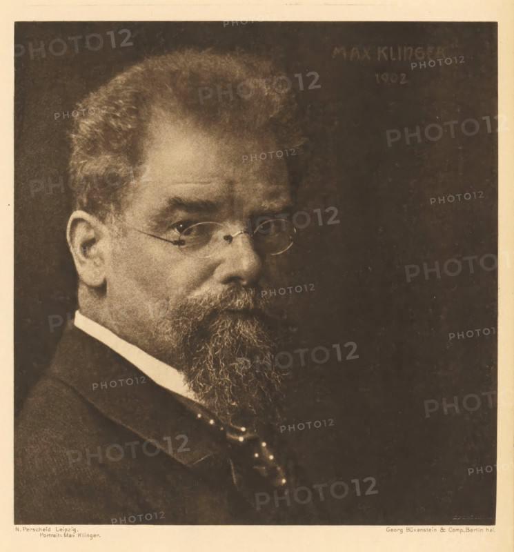 Portrait: Max Klinger, Portrait of Max Klinger, page, photomechanical print, photographer: Nicola Perscheid, cliché maker: Büxenstein & Comp., Georg, Berlin, 1902, 1902 - 1903, printer (person), paper, photoaquatint, height 165 mm x width 159 mm, Print ten of fourteen prints at the back of the book., Person, historical persons, A sepia-toned portrait of an older man shown from the shoulders up, featuring a full beard and mustache, round eyeglasses, a high-collared shirt, a suit jacket, and a patterned tie, with a dark plain background and a light margin around the image.