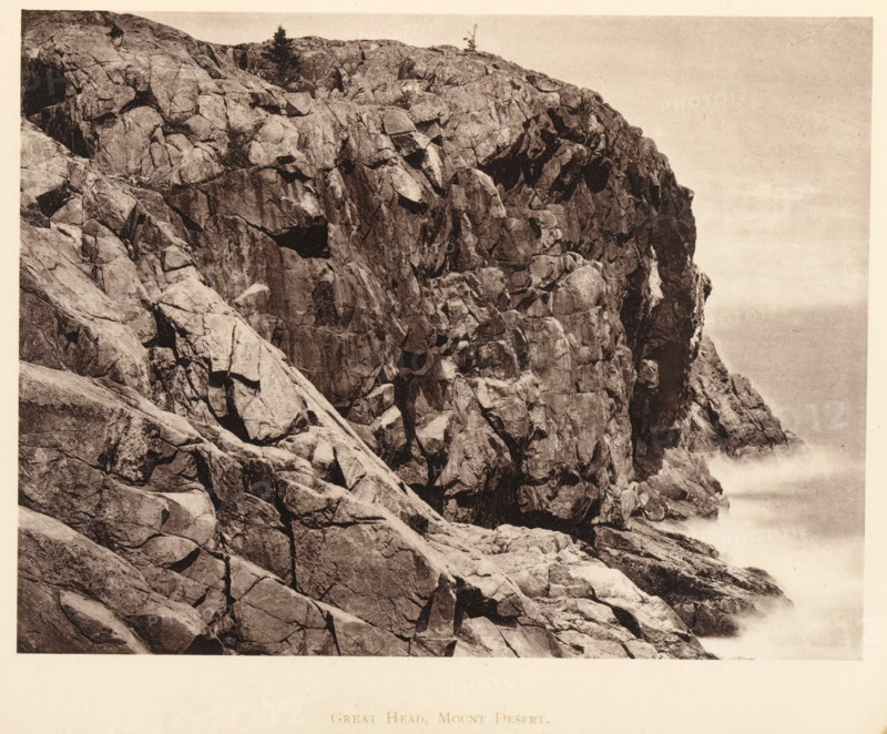 Great Head, Mount Desert, View of Great Head on Mount Desert Island, Maine, page, photomechanical print, c. 1875 - in or before 1880, North America, Mount Desert Island, paper, collotype, photoprint, height 131 mm x width 173 mm, cape (coast), A sepia-toned photograph showing a steep rocky cliff face with large angular boulders and fractured rock surfaces, textured cracks and crevices, sparse vegetation including a few small trees near the top, and waves or sea spray visible at the base where the cliff meets the water, with a pale sky occupying the upper right area.