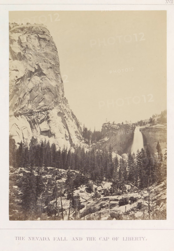The Nevada Fall and the Cap of Liberty, View of the Nevada Fall and Liberty Cap in the Yosemite Valley, photograph, page, number: 'XVII.', photographer: Carleton E. Watkins, Yosemite Valley, c. 1860 - in or before 1868, North America, California, paper, albumen print, height 206 mm x width 156 mm, waterfall, mountains, rock-formations, dale, valley, Nevadawaterval, A sepia-toned landscape photograph showing a steep granite cliff on the left with visible rock striations and ledges, a waterfall on the right cascading from a rocky rim into a tree-filled valley below, dense conifer trees covering the mid and lower slopes, scattered boulders and rocky outcrops in the foreground, and an expansive pale sky occupying the upper portion of the image.