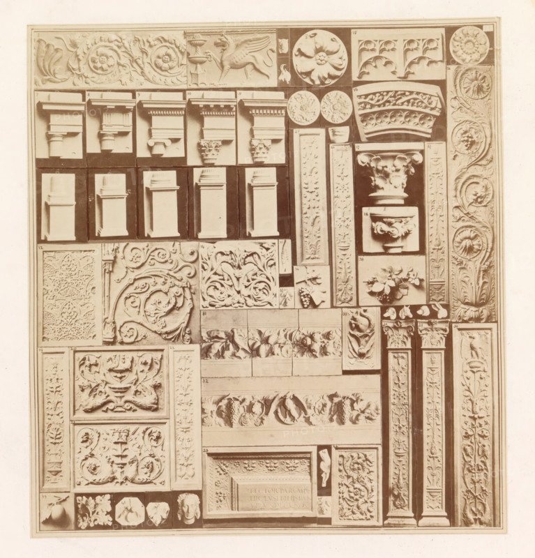 Casts of ancient building fragments, photograph, page, photographer: HG Smith, photographer: HW Tupper, c. 1864 - in or before 1874, paper, albumen print, height 184 mm x width 170 mm, column, pillar, architecture, architectural detail, stylistic and formal differentiation of art, A rectangular panel filled with numerous carved plaster or stone relief fragments arranged in a grid, showing a variety of architectural elements and ornamental motifs in a uniform pale tone; there are sections depicting capital tops, column shafts, floral rosettes, scrolling acanthus leaves, grape clusters, stylized vines, circular medallions, rectangular plaques with intricate arabesque and foliate patterns, projecting cornice and molding profiles, small sculpted heads and figurative fragments, and narrow vertical pilaster-like strips with repeating leaf and flower carvings, all photographed against a darker background that highlights the raised details.