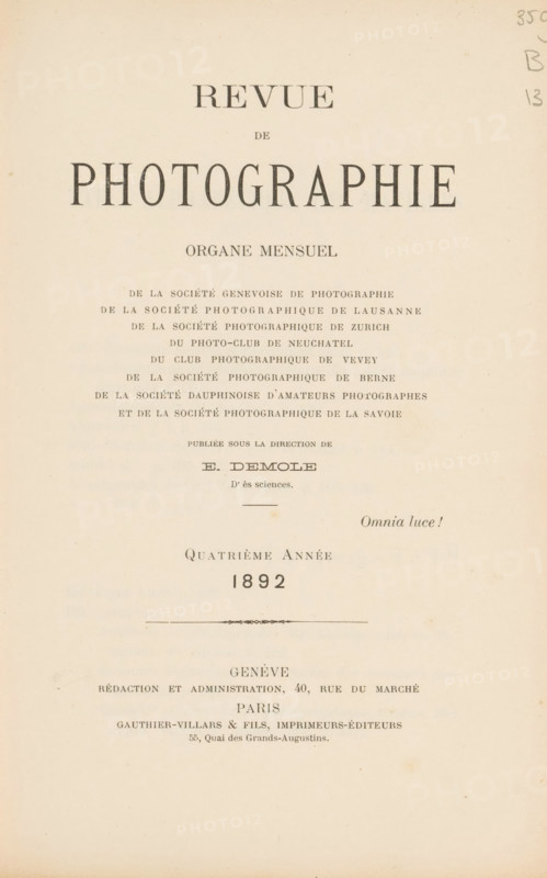 Revue de photographie, book, annotation: 'JAN, 1995', editor (person who revises): Eugène Demole, c. 1892, editor (person who revises), pasteboard, paper, textile materials, printing, collotype, photoaquatint, cocoa marbled paper, height 245 mm x width 168 mm x thickness 30 mm, A cream-colored page with centered rows of printed dark serif lettering of various sizes arranged down the upper and middle area, a small decorative horizontal ornament about halfway down, and faint pencil marks at the top right; the paper shows slight discoloration and small spots near the edges.