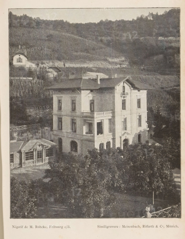 View of a villa in a mountainous landscape, probably in Switzerland, page, photomechanical print, photographer: M. Röbeke, Switzerland (possibly), cliché maker: Meisenbach, Riffarth & Cie., Munich, c. 1893 - in or before 1898, Bavaria, paper, autotypie, height 152 mm x width 125 mm, villa, low hill country, A multi-story pale building with arched ground-floor openings and rectangular windows on upper levels stands in front of a hillside covered with rows of vegetation and scattered small structures; the building has decorative balcony railings, a pitched roof with chimneys, and an ornamental gable above one facade, while leafy trees fill the foreground and a smaller structure with large windows and a pitched roof sits to the left.