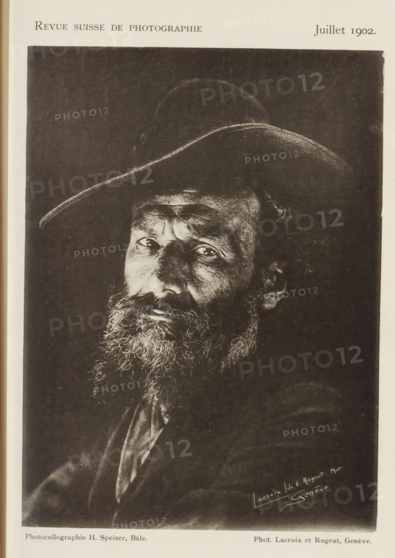 Portrait of an unknown man, page, photomechanical print, inscription: 'Revue Suisse de photographie, Juillet 1902', photographer: Lacroix fils & Rogeat, maker: Hans Speiser, c. 1897 - in or before 1902, paper, collotype, photoprint, height 154 mm x width 114 mm, historical persons, A black and white portrait of an older man wearing a wide-brimmed hat, shown from the chest upward, with a full beard and mustache, deep facial lines, and light reflecting in his eyes, set against a dark background.