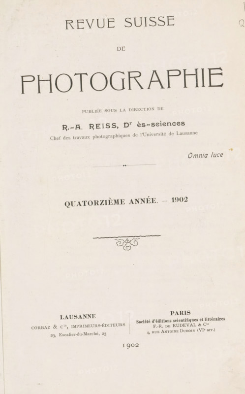 Revue suisse de photographie, book, collector's mark: 'Dr. Frans de vos, 64 tot Rivierenlaan, 64, Deurne, ...', editor (person who revises): Rodolphe Archibald Reiss, 1902, Rodolphe Archibald Reiss, editor (person who revises), textile materials, paper, linen (material), transparent paper, printing, autotype, collotype, height 234 mm x width 172 mm x thickness 34 mm, A vertical page with a pale, slightly textured background showing a large title area at the top and centered ornamental elements and smaller text blocks below; the top contains a wide word in large stylized letters, followed by a narrower word beneath it and a prominent word in very large uppercase letters spanning across the page; below that are several lines of smaller printed text with a small decorative horizontal rule and a small script-style word to the right; further down is a bold centered line of text indicating an annual notation with a year at its end, and beneath it a thin wavy horizontal line with a small flor...
