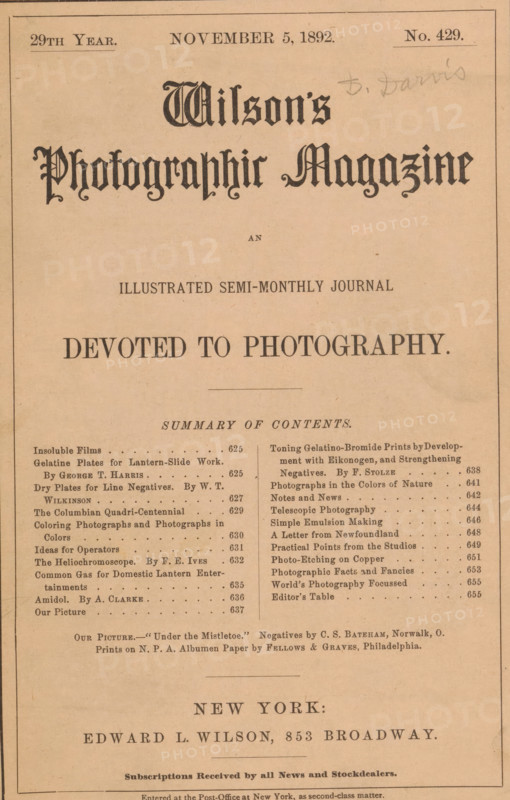 Wilson's photographic magazine, magazine, name: 'D. Davis', publisher: Edward Livingston Wilson, New York (city), 1892-11-05, Edward Livingston Wilson, publisher, North America, paper, printing, wood engraving, autotype, albumen print, height 257 mm x width 176 mm x thickness 4 mm, A vertically oriented aged paper cover with a pale tan background and a thin border, featuring a large ornate title in decorative blackletter type near the top center and a smaller decorative line beneath it, a centered bold heading further down, and two narrow columns of smaller printed entries separated by a vertical rule in the middle section; the top margin includes a few small printed lines and a faint pencil inscription at the upper right, and the bottom portion shows a centered line of larger text followed by another horizontal rule and additional smaller printed lines toward the lower edge.