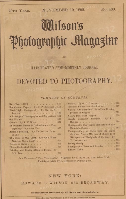 Wilson's photographic magazine, magazine, publisher: Edward Livingston Wilson, New York (city), 1892-11-19, Edward Livingston Wilson, publisher, North America, paper, printing, wood engraving, autotype, collotype, height 255 mm x width 177 mm x thickness 4 mm, A rectangular page with a tan background and a thin dark border containing a large ornate title in decorative black lettering near the top, a smaller centered line of text below it, a bold horizontal heading in large capital letters beneath that, and two columns of smaller printed lines and dot leaders filling the central area. The page shows faint smudges and aging marks, with a curved pencil or pen mark crossing part of the right column, and a thin horizontal rule separating sections. The lower portion displays centered lines of larger spaced lettering above an area of smaller printed lines and a narrow double-line border near the bottom. The overall appearance is of aged paper with printed typography in varying sizes and style...