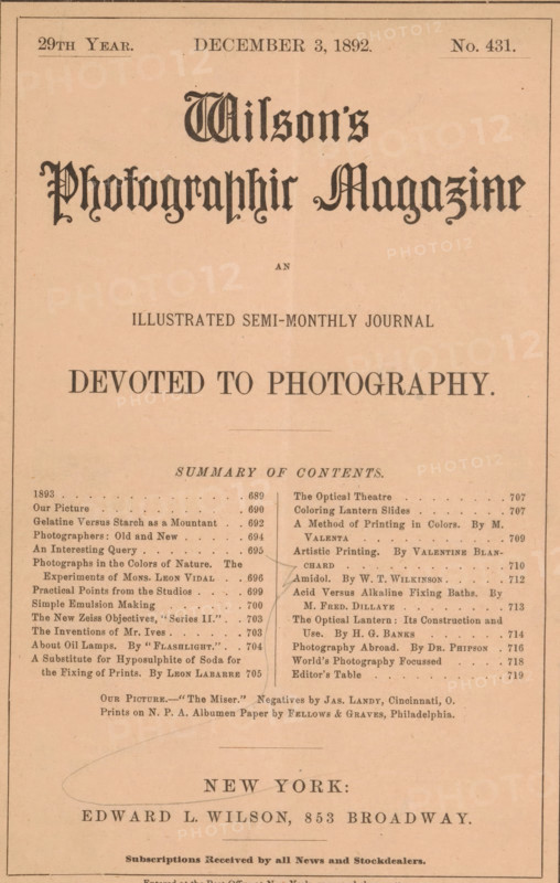 Wilson's photographic magazine, magazine, publisher: Edward Livingston Wilson, New York (city), 1892-12-03, Edward Livingston Wilson, publisher, North America, paper, printing, wood engraving, autotype, albumen print, height 256 mm x width 175 mm x thickness 4 mm, The image shows a portrait-oriented page with a light tan background and a thin dark border around the edges; the top third features a large ornate black title in a decorative script centered near the top, with smaller lines of dark text below it, and a small gap before a bold centered declaration in uppercase letters; the middle contains a densely printed two-column list of short entries with dot leaders and occasional darker marks and underlines between the columns, and faint pencil or pen curved lines crossing parts of the left and center; the lower area shows a larger centered place name in uppercase with a decorative horizontal oval-like pencil mark overlapping it, followed by a line of smaller dark text and a narrow rul...