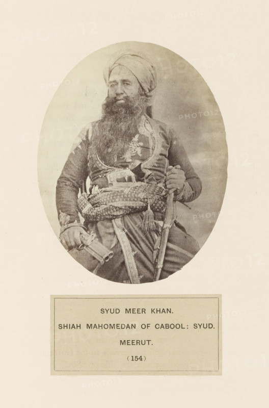 Portrait of Meer Khan from Meerut, Uttar Pradesh, India, photograph, page, number: '(154)', inscription: 'SYUD meer KHAN., SHIAH MAHOMEDAN OF CABOOL: SYUD., meerUT', Meerut, c. 1858 - in or before 1868, photographer, North India, paper, albumen print, height 120 mm x width 95 mm, head-gear: turban, human races, peoples, nationalities, An oval sepia photograph of a seated man wearing a turban and a long beard, dressed in ornate clothing with embroidered patterns and a decorative sash around his waist, holding a curved sword in one hand and a cylindrical object in the other, set against a plain light background with a rectangular bordered card below the portrait.