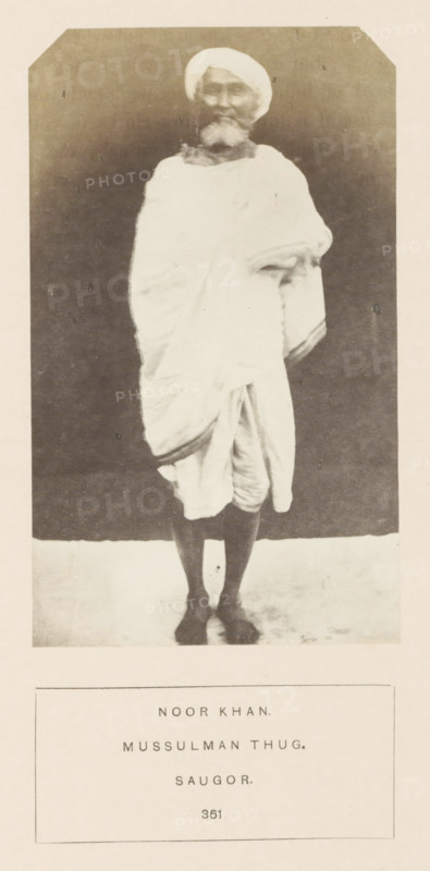 Portrait of Noor Khan, a thug who was imprisoned in Jabalpur, Madhya Pradesh, India, photograph, page, number: '361', inscription: 'NOOR KHAN., MUSSULMAN THUG., SAUGOR.', photographer: James John Waterhouse (possibly), Jabalpur, 1862, Central India, paper, albumen print, height 133 mm x width 80 mm, head-gear: turban, human races, peoples, nationalities, criminals, A full-length black-and-white portrait of an older man standing against a dark backdrop, wearing a light-colored turban and a draped garment that covers his torso and falls to his knees, with one arm folded under the drapery and the other resting at his side; he has a beard and moustache, bare lower legs and feet visible, and the image is framed with a pale border and a rectangular caption area below containing printed lines of text.