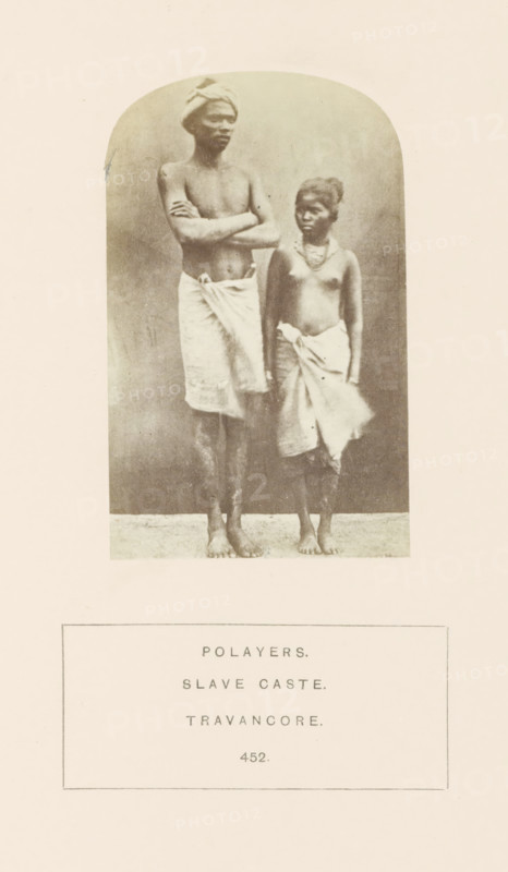 Portrait of an unknown man and woman from Travancore, India., photograph, page, Travancore was a historic country in the southern tip of India., inscription: 'POLAYERS., SLAVE CASTE., TRAVANCORE.', number: '452.', Travancore, c. 1865 - in or before 1875, photographer, paper, albumen print, height 99 mm x width 61 mm, human races, peoples, nationalities, A sepia-toned photograph shows two barefoot people standing on a flat surface against a neutral backdrop, one taller person with crossed arms and a wrapped cloth around the waist and a head covering, and a shorter person beside them wearing a wrapped cloth around the waist and a necklace, both with bare torsos and facing slightly to the side.