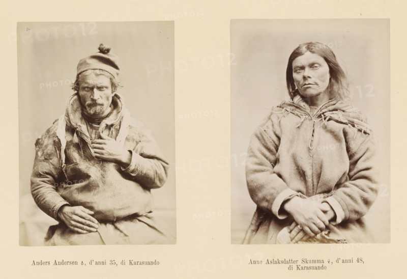 Two portraits of Anders Andersen and Anna Aslaksdatter Skumma, Anna Aslaksdatter Skumma ?, d' anni 48, di Karasuando, Anders Andersen ?, d' anni 35, page, Left a front view of Anders Andersen, right a front view of Anna Aslaksdatter Skumma., number: 'Tavola XIX.', photographer: Paolo Mantegazza, Scandinavia, photographer: Carlo Pietro Stefano Sommier, c. 1870 - in or before 1880, paper, albumen print, height 254 mm x width 340 mm, Photo in photo section at the back, adult man (front view), adult woman (front view), A sepia-toned image showing two vertical portrait photographs side by side on a pale background, each framed by a lighter border; the left portrait features a middle-aged man wearing a knit cap with a small pom-pom and layered clothing with visible wear, a scarf around his neck, a rugged face with a mustache and beard, one hand resting on his chest and the other on his lap; the right portrait shows a woman wearing a heavy, fringed outer garment with a tied collar, shoulder-l...
