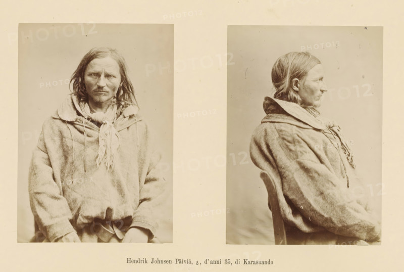 Two portraits of Hendrik Johnsen Päivä, Hendrik Johnsen Päivä, ?, d' anni 35, di Karasuando, page, Left a front view, right a side view., number: 'Tavola IV.', photographer: Paolo Mantegazza, Scandinavia, photographer: Carlo Pietro Stefano Sommier, 1870 - 1880, Paolo Mantegazza, Carlo Pietro Stefano Sommier, paper, albumen print, height 254 mm x width 340 mm, Photo in photo section at the back, adult man (side view, profile), adult man (front view), A sepia-toned photograph shows two portraits of the same person mounted side by side on a light background; the left portrait is a frontal view and the right is a profile view facing right. The person has long straight hair parted near the middle and a narrow face with a mustache and faint facial hair. They wear a textured, loose-fitting garment with a wide collar and a fringed scarf or cloth tied around the neck. In the profile view the person is seated on a wooden chair seen at the back, and the fabric of the garment appears thick and sli...