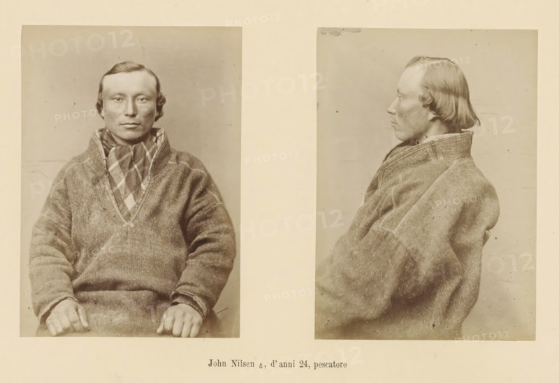 Two portraits of the fisherman John Nilsen, John Nilsen ?, d' anni 24, pescatore, page, Left a front view, right a side view., number: 'Tavola VI.', photographer: Paolo Mantegazza, Scandinavia, photographer: Carlo Pietro Stefano Sommier, 1870 - 1880, Paolo Mantegazza, Carlo Pietro Stefano Sommier, paper, albumen print, height 254 mm x width 340 mm, Photo in photo section at the back., adult man (sideview, profile), adult man (front view), A sepia-toned image showing two photographic portraits of the same man mounted side by side on a light background; the left portrait is a frontal view of a seated man with short dark hair and a neutral expression wearing a textured sweater and a patterned scarf, his hands resting in his lap, and the right portrait is a profile view of the same man facing left wearing the same sweater with visible stitching and a folded collar.