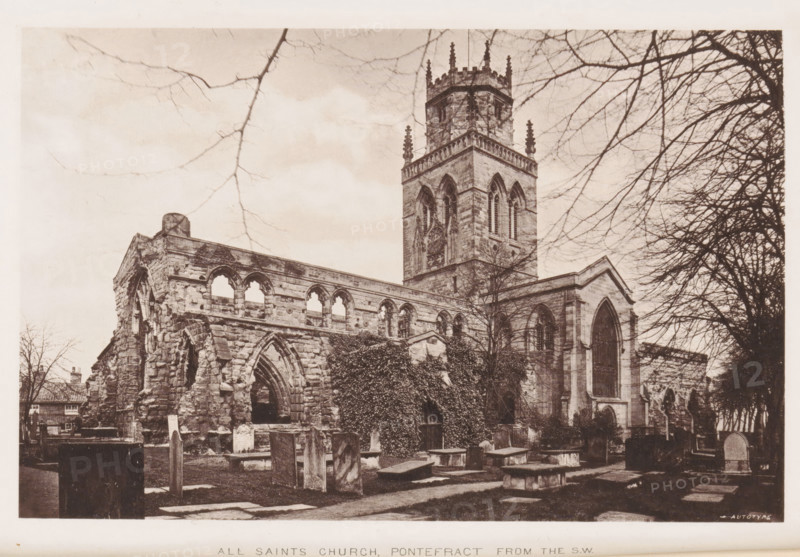 View of All Saints Church in Pontefract, All Saints Church, Pontefract from the SW, page, photomechanical print, Pontefract, cliché maker: Autotype Company, The, c. 1882 - in or before 1887, photographer, clichémaker, paper, collotype, photoprint, height 114 mm x width 177 mm, church (exterior), A sepia-toned photograph showing a stone church with a tall square tower topped by battlements and pinnacles, Gothic arched windows visible on the tower and the adjacent nave, and a partly ruined section with arched openings and rough stonework in the foreground; bare tree branches frame the top and right edges of the scene, ivy climbs parts of the exterior walls, and several weathered gravestones and flat stone slabs occupy the grassy churchyard in front.