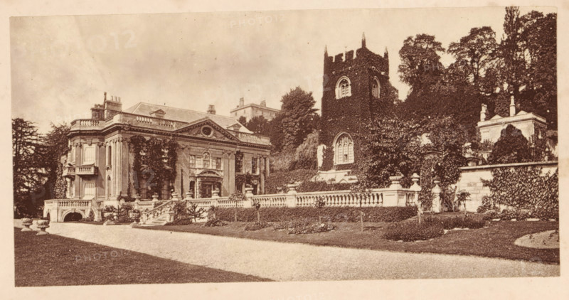 Widcombe Church and Widcombe House, Bath, View of Widcombe Church and Widcombe House in Bath, page, photomechanical print, photographer: Foote, cliché maker: Woodbury Permanent Photographic Printing Company (possibly), c. 1871 - in or before 1876, paper, Woodburytype, height 67 mm x width 136 mm, Print opposite title page, behind semi-transparent cover., church (exterior), civic architecture, edifices, dwellings, A wide sepia-toned photograph of a stately building and adjacent tower set behind a low stone balustrade, with a gravel drive and trimmed lawns in the foreground; the main building has classical architectural details including tall columns, ornate pediments, balcony elements, and multiple sash windows partially covered by climbing plants, while the tower beside it is rectangular with crenellated top and arched windows and is heavily clad in ivy; there are stone steps, decorative urns, sculpted stonework along the balustrade, dense trees and shrubbery rising behind and around t...