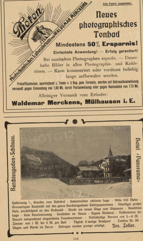 Mountain landscape with hotel, page, photomechanical print, c. 1898 - in or before 1903, paper, autotypie, height 65 mm x width 81 mm, hotel, hostelry, inn, mountains, A vertically oriented aged printed page with an upper advertisement block showing a circular sunburst graphic with a diagonal ribbon and a small central illustration, bold headline lettering, and several lines of smaller printed text; below this block a framed rectangular photograph depicts a snowy mountain village scene with a foreground fence, a cluster of buildings including a structure with a pointed steeple, and mountains in the background under a cloudy sky; the page margins and lower area contain additional printed paragraphs and decorative border elements.