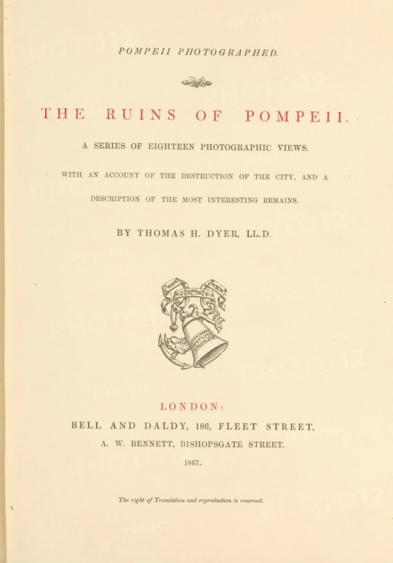 The ruins of Pompeii : a series of eighteen photographic views, book, annotation: '2, 40 ... 1867', Dec 25 1867', bookplate: 'SFJ', writer (clerical worker): Thomas H. Dyer, publisher: Bell & Daldy, London, publisher: Alfred William Bennett, 1867, Thomas H. Dyer, Bell & Daldy, Alfred William Bennett, writer (clerical worker), publisher, pasteboard, paper, textile materials, printing, albumen print, color on cut, height 282 mm x width 222 mm x thickness 23 mm, A cream-colored page with centered printed elements, including a decorative floral motif near the top, a line of large spaced capital letters in a muted red ink, several lines of smaller dark gray serif text arranged beneath, a detailed black line illustration of a bell with ornate ribbons and scrollwork in the middle of the page, and additional lines of dark gray and muted red text lower down, all set on a slightly aged paper background.
