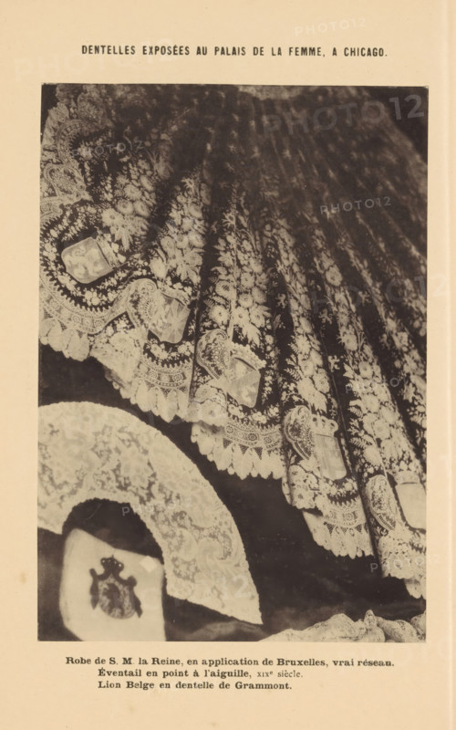 Eventail and point à l'aiguille, Dress with embroidery of the Belgian Queen Maria Hendrika, a lace collar and the coat of arms of Belgium, Robe de SM la Reine, en application de Bruxelles, vrai réseau, Lion Belge en dentelle de Grammont, Dentelles exposées au Palais de la Femme, a Chicago, page, photomechanical print, inscription: 'XIXe siècle.', Chicago, c. 1888 - in or before 1893, North America, Illinois, paper, collotype, photoprint, height 164 mm x width 115 mm, dress, gown, embroidery (ornamentation), A sepia-toned photograph showing a close-up of richly patterned lace fabric with floral motifs and scalloped edges, draped in folds across the frame, and a round lace piece positioned near the lower left with an embroidered emblem on a dark background.