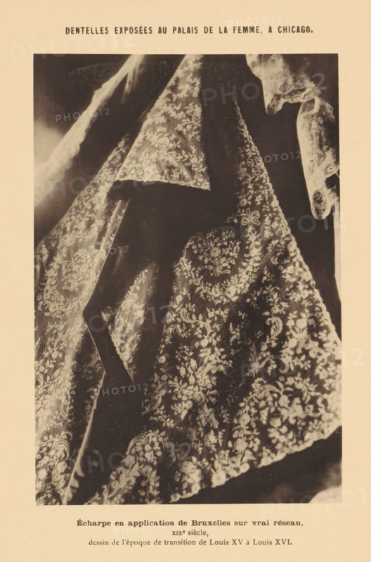 Scarf with embroidery, Écharpe en application de Bruxelles sur vrai réseau, Dentelles exposées au Palais de la Femme, a Chicago, page, photomechanical print, inscription: 'XIXe siècle, dessin de l'époque de transition de Louis XV à Louis XVI.', Chicago, c. 1888 - in or before 1893, North America, Illinois, paper, collotype, photoprint, height 164 mm x width 111 mm, accessories (, clothing), A sepia-toned photograph of draped lace fabric with intricate floral and scroll patterns, showing layered folds and scalloped edges, with portions of darker background visible through the translucent textile and contrasting lighter embroidered motifs.