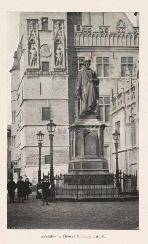 La statue de Thierry Martens, à Alost, Statue of Dirk Martens on the Grote Markt in Aalst, page, photomechanical print, monogram: 'AN', maker: Jean Malvaux, photographer: unknown, c. 1906 - in or before 1911, paper, autotypie, height 176 mm x width 107 mm, Print on second unnumbered page after title page., Person, Dirk Martens, monument, statue, Aalst (East Flanders), A tall stone statue of a robed figure stands on a large ornate pedestal surrounded by a decorative metal fence, positioned in front of a multi-story stone building with Gothic architectural details and carved niches containing statues; several vintage street lamps rise near the pedestal, and a small group of people in period clothing stand on the cobbled ground nearby.