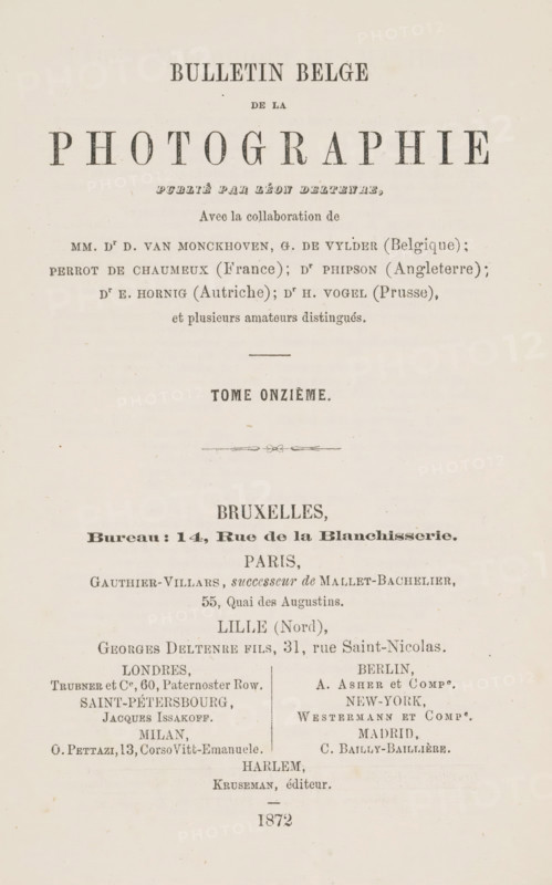 Bulletin belge de la photographie, magazine, annotation: 'OCT, 1997', editor (person who revises): Léon Deltenre-Walker, printer (person): L. Truyts, Brussels, publisher: various manufacturers, 1872, editor (person who revises), printer (person), textile materials, pasteboard, biological material, paper, linen (material), leather, printing, decorated paper, shell marbled paper, Woodburytype, height 240 mm x width 160 mm x thickness 17 mm, A cream-colored page showing a centered layout of printed elements in various serif typefaces and sizes, with a large bold word near the top in very large capital letters, smaller lines of text arranged beneath it in different styles, and horizontal decorative flourishes separating sections; the lower half features multiple columns of smaller text blocks and names aligned vertically, all printed in dark ink, with faint paper texture and small spots and aging marks visible across the page.